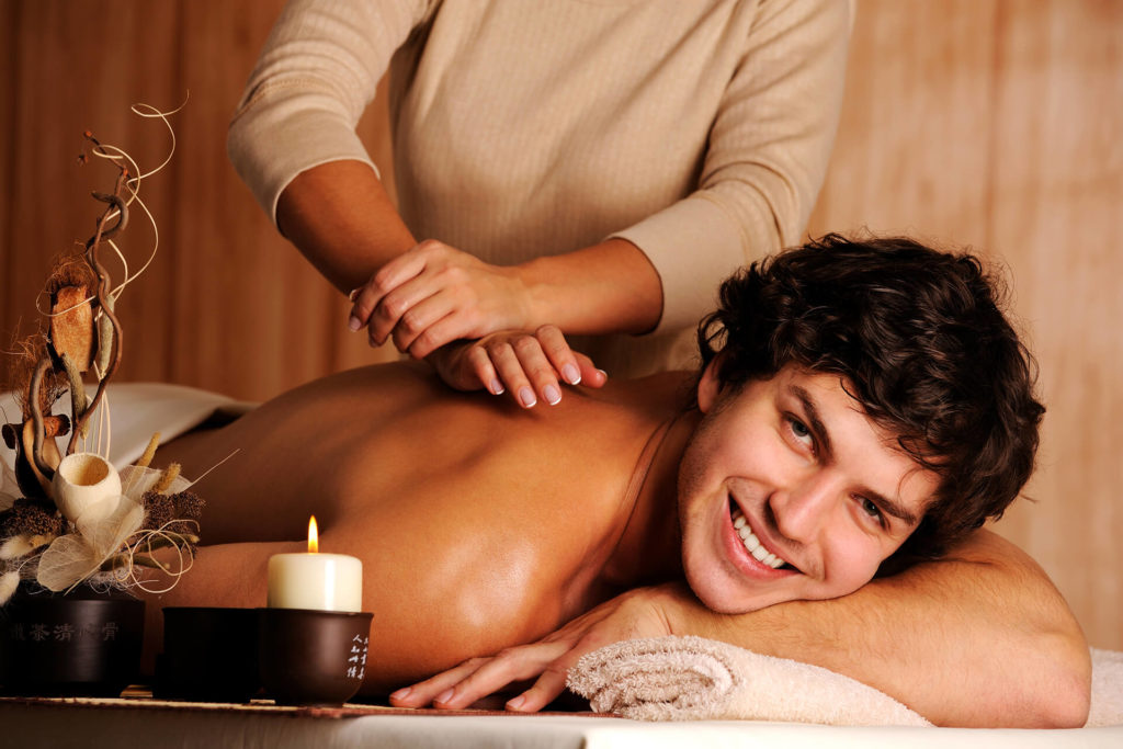 massage and wellness masseuse and man receiving a massage