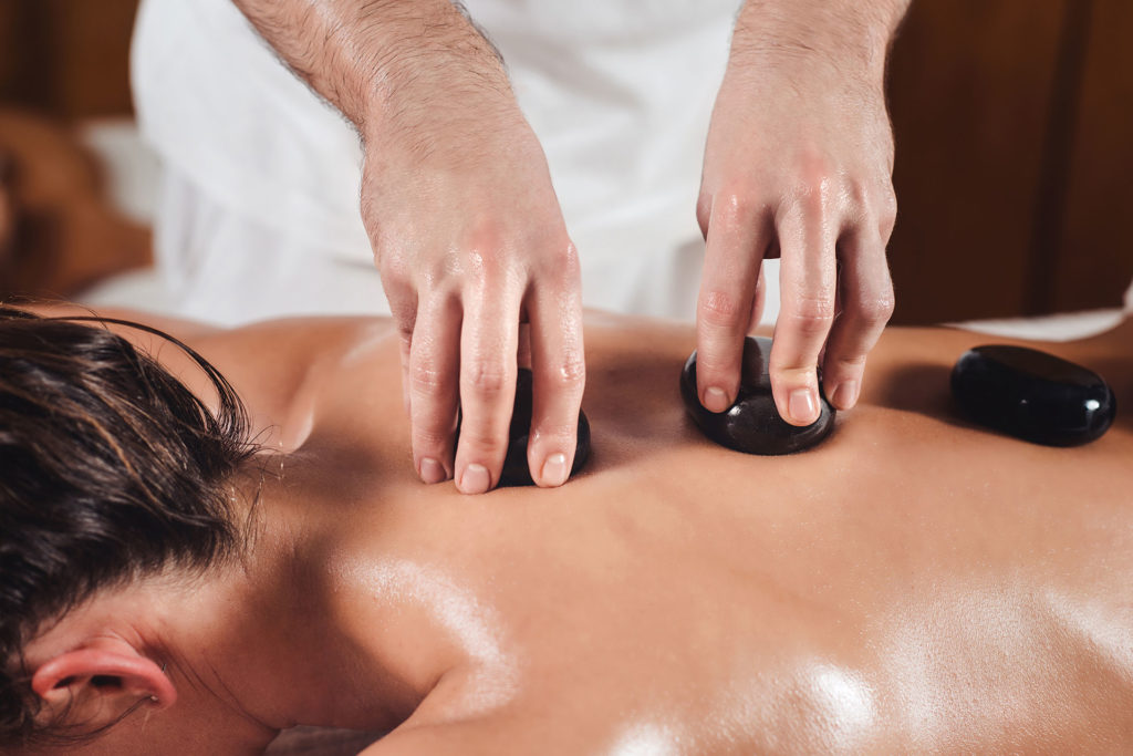 a person receiving a hot stone massage